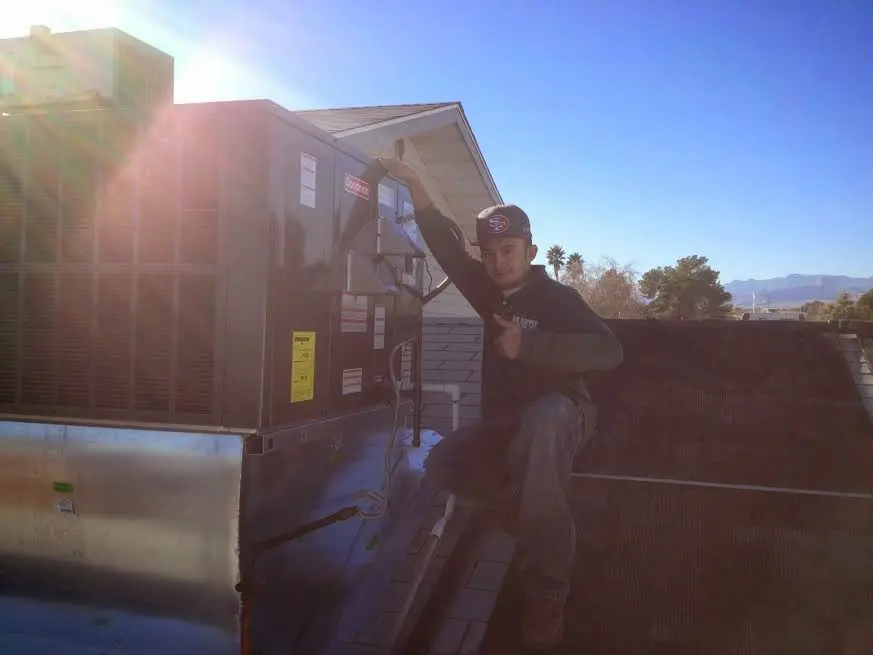 HVAC technician performing Heat Pump Repair on a rooftop unit in Hueytown